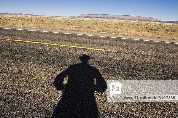 Shadow of cowboy on remote highway