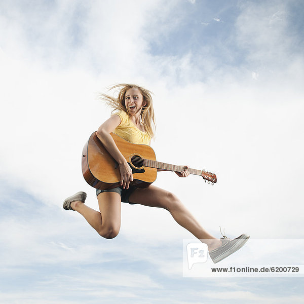 Europäer  Frau  In der Luft schwebend  springen  Gitarre  spielen