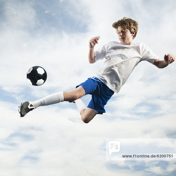 Jugendlicher Europäer In der Luft schwebend treten Fußball Ball Spielzeug