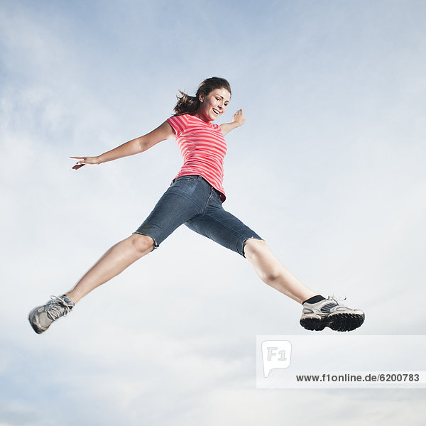 Caucasian teenager jumping in air