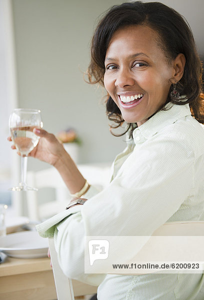 Black woman drinking white wine