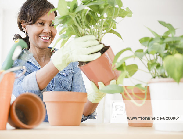 Black woman potting plants