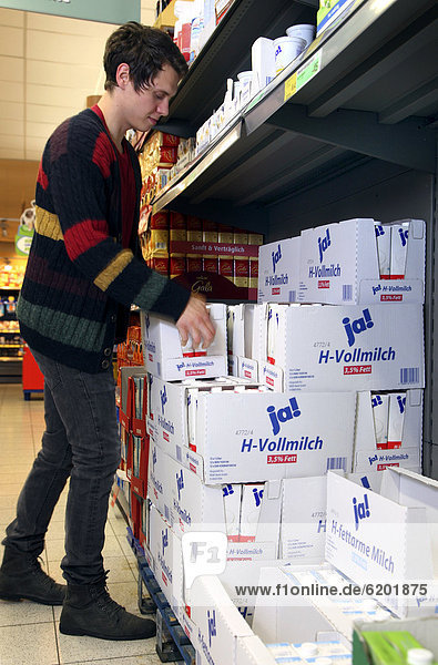Man buying JA-brand long-life whole milk  food hall  supermarket  Germany  Europe