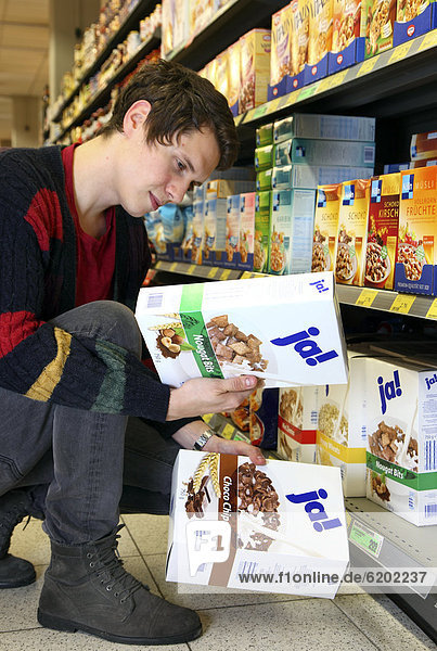 Mann kauft Mueslimischung der JA-Marke ein  Lebensmittelabteilung  Supermarkt  Deutschland  Europa