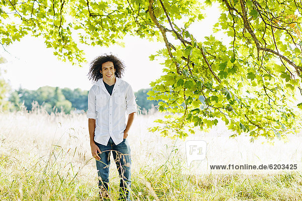 Mixed race teenager standing in remote field
