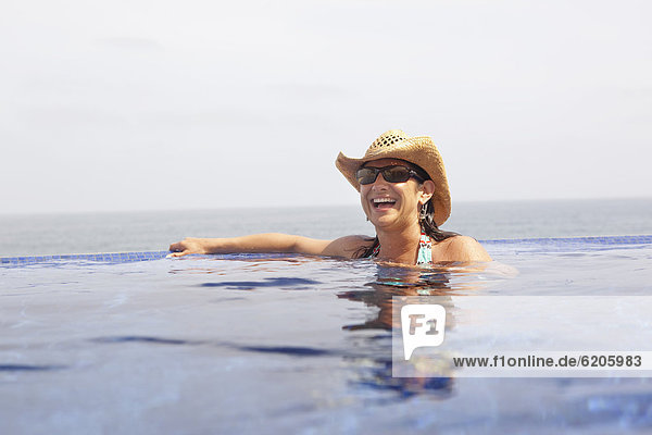 Hispanic woman enjoying swimming pool