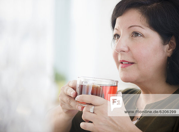 Hispanic woman drinking tea