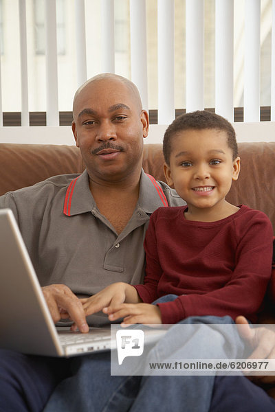 Antiguan father using laptop with son