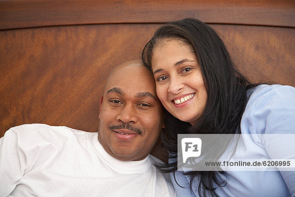 Antiguan man laying in bed with wife
