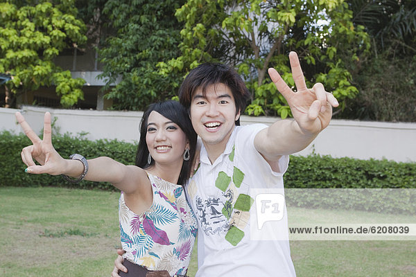 Asian couple making peace sign