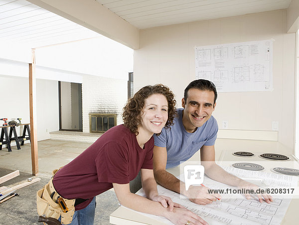 Couple looking at blueprint in kitchen