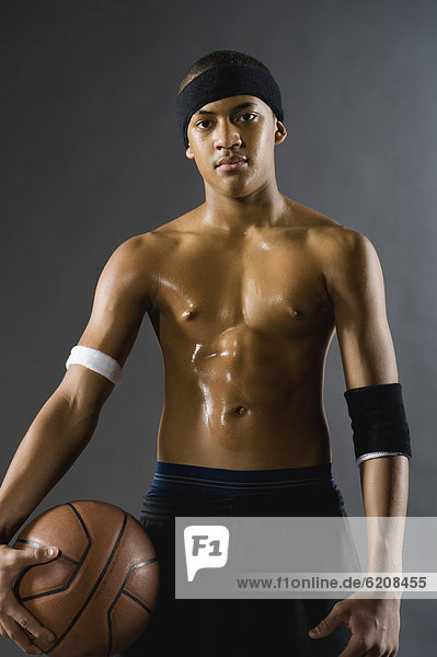 Mixed race basketball player holding ball
