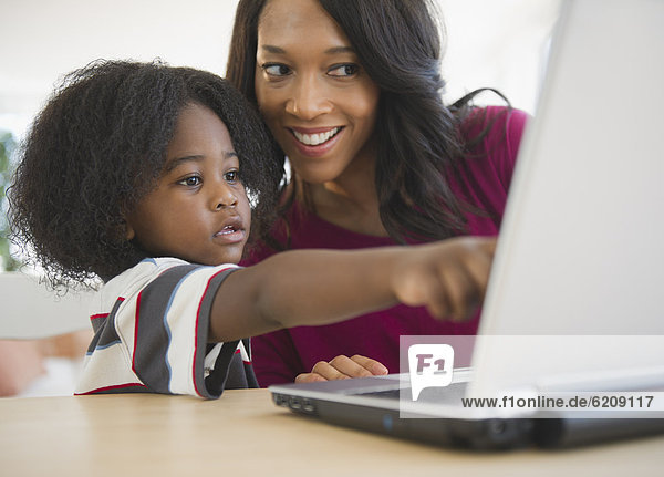 African American mother and son using laptop together