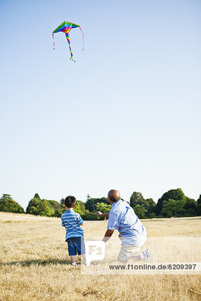 Chinese grandfather and grandson flying kite