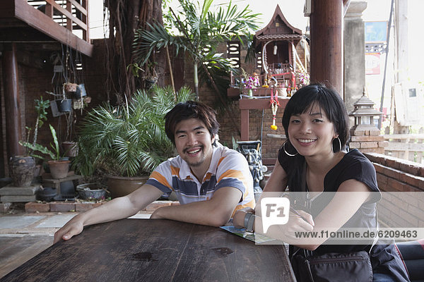 Asian couple sitting at patio table