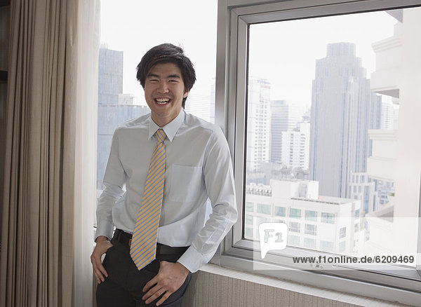 Chinese businessman laughing near window