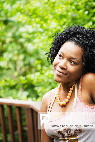 African woman looking pensive on patio