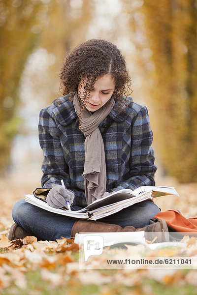 Caucasian woman doing home work in autumn leaves