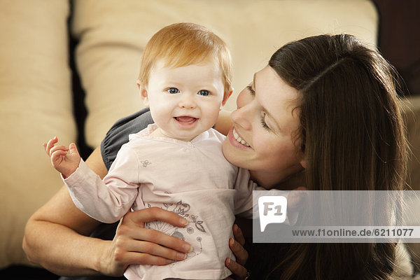 Caucasian mother smiling at baby daughter