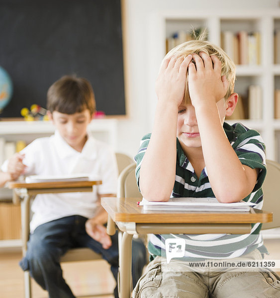 sitzend  Europäer  Schreibtisch  Enttäuschung  Junge - Person  Klassenzimmer