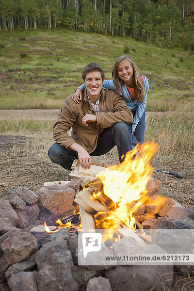 Caucasian couple enjoying campfire