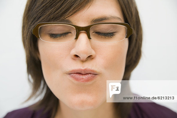 Hispanic woman in eyeglasses puckering for kiss