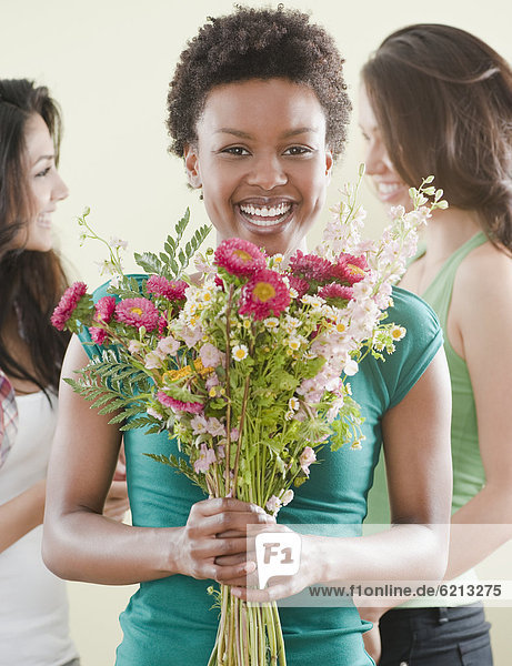 African woman holding bouquet of flowers