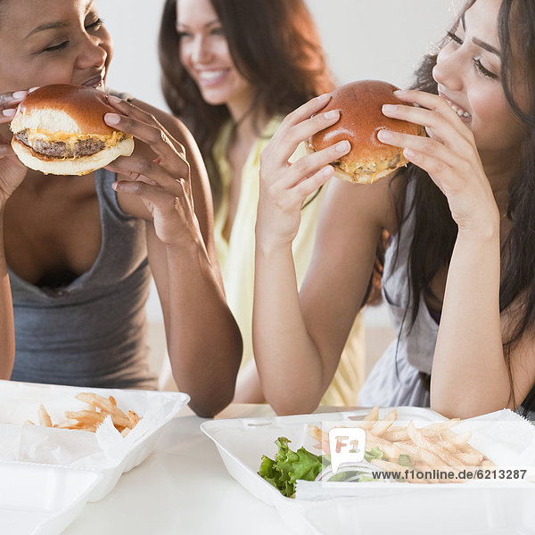 Friends eating take-out hamburgers and french fries