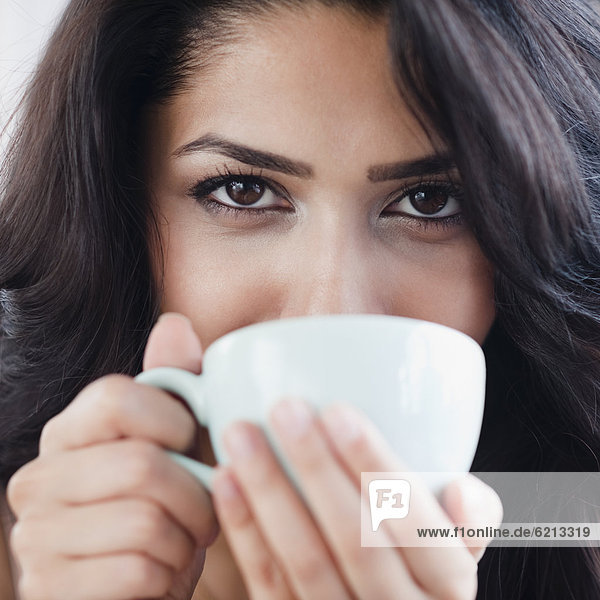 Close up of Middle Eastern woman drinking coffee