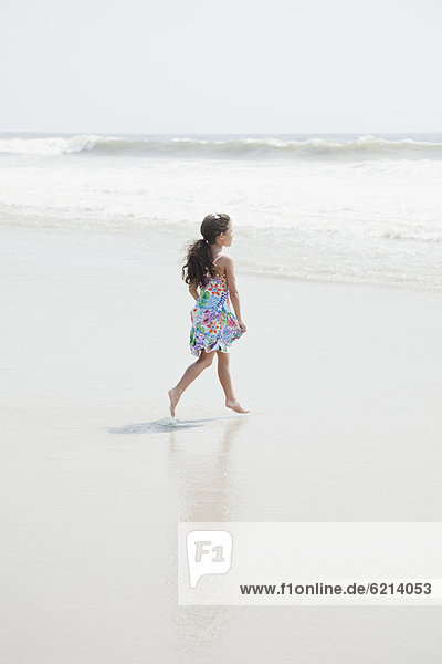 Hispanic girl walking on beach