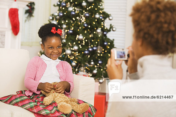 African mother taking picture of daughter at Christmas