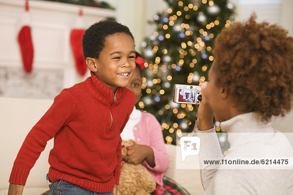 African mother taking picture of son at Christmas