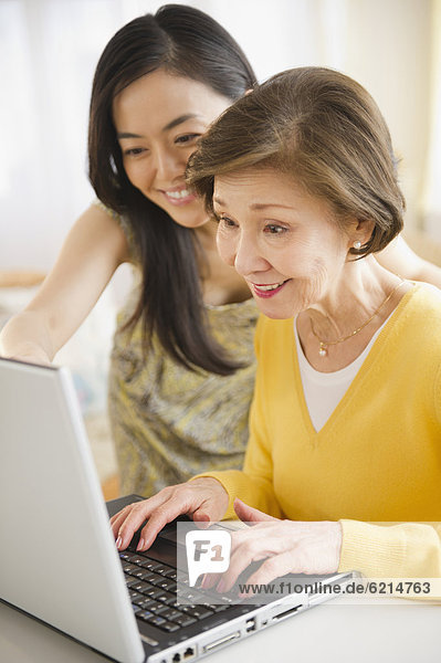 Japanese mother and daughter using laptop together