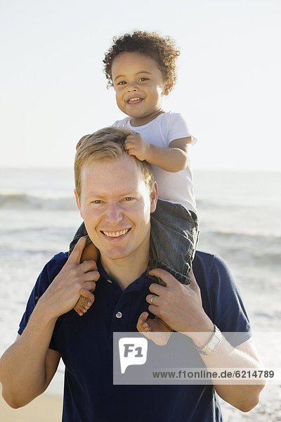 Caucasian father carrying mixed race son