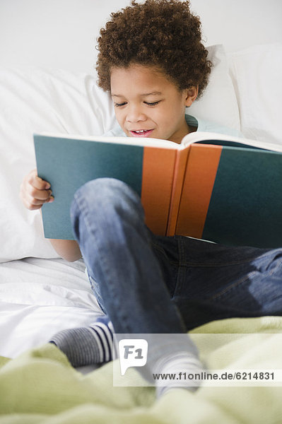 Buch  Junge - Person  Bett  schwarz  Taschenbuch  vorlesen