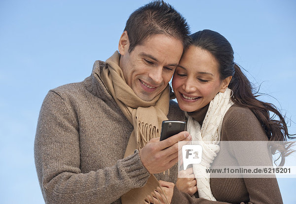 Hispanic couple looking at cell phone