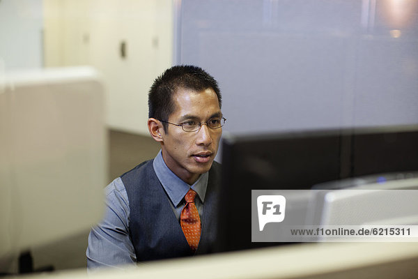 Mixed race businessman using computer in office