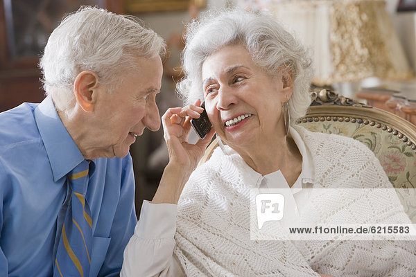 Senior Hispanic couple using cell phone