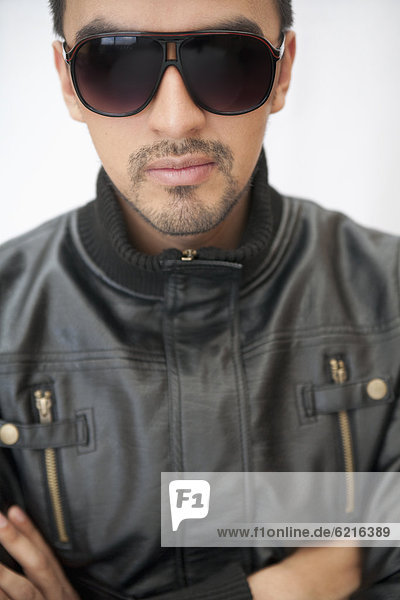 Hispanic man in sunglasses and leather coat