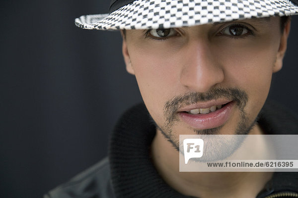 Hispanic man in hat and leather coat