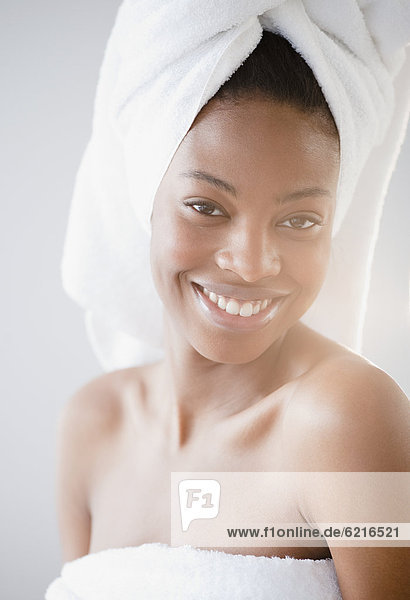 Smiling mixed race woman with head in towel
