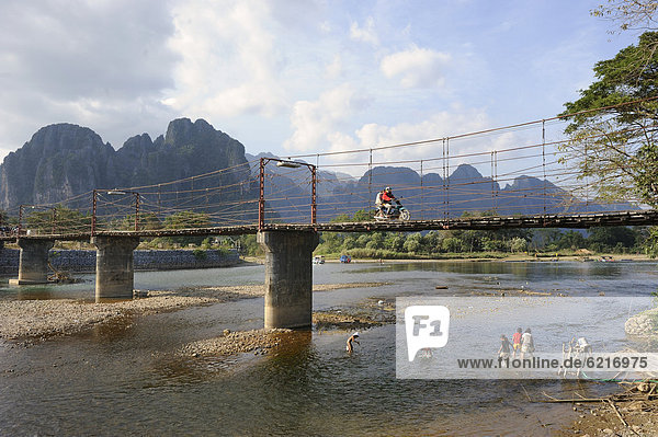 Bridge across the Nam Song river  karst mountain range at the back  Vang Vieng  Laos  Southeast Asia