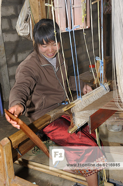 Weberin arbeitet an einem Handwebstuhl in einer Seidenmanufaktur bei der Stadt Phansavan  Laos  Südostasien  Asien