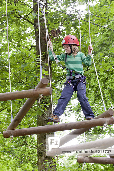 Girl  8 years  climbing at Hochseilgarten  high ropes course  Straubing  Bavaria  Germany  Europe