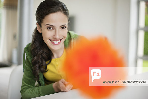 Happy woman holding a feather duster