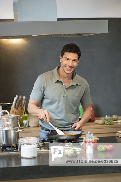 Mann bei der Zubereitung von Speisen in der Küche