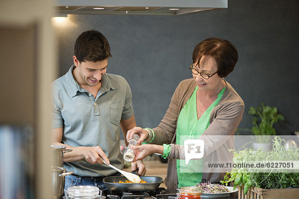Frau  die ihrem Sohn beim Kochen hilft