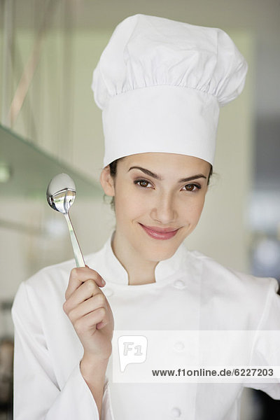 Happy female chef holding a spoon