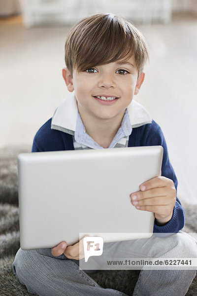 Portrait of a boy holding a digital tablet
