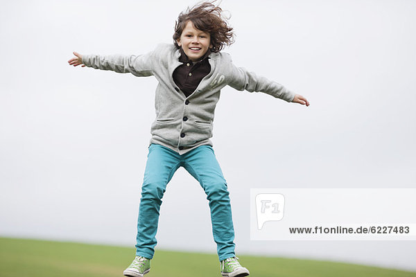 Porträt eines Jungen beim Springen auf einem Feld